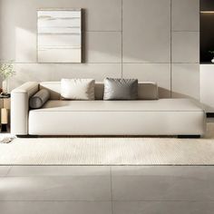 a modern living room with white furniture and neutral colors on the walls, along with an area rug