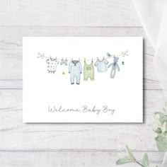 a card with baby clothes hanging on a line