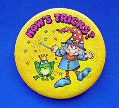 a yellow button that says how's tricks? with a cartoon character on it