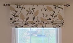 a window with a bird print roman blind and matching valance in front of it