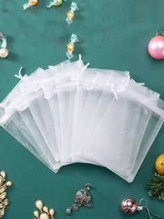 five bags of clear plastic sitting on top of a green surface next to christmas decorations