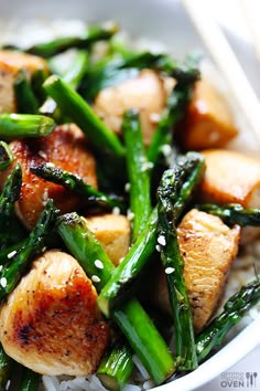 a white bowl filled with chicken and green beans covered in broccoli stir fry