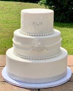 a three tiered white wedding cake sitting on top of a table