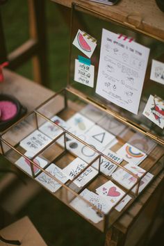 a display case filled with lots of cards and magnets on top of a table