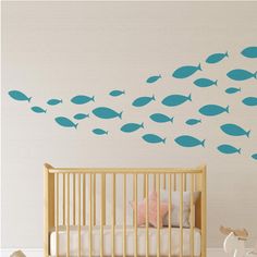 a baby's room with blue fish decals on the wall