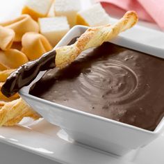 a white bowl filled with chocolate dip and chips