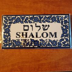 a wooden table with a blue and white plate on it that says shalohm