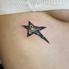 a small star tattoo on the side of a woman's stomach, which is black and white