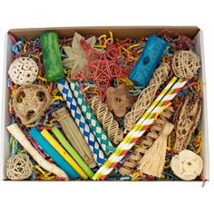 an open box filled with assorted crafting items and paper straws on top of each other