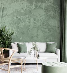 a living room with green walls and white furniture in the corner, along with plants