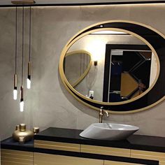 a bathroom with a sink, mirror and lights on the wall in front of it