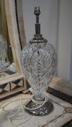 a glass lamp sitting on top of a table next to a mirror