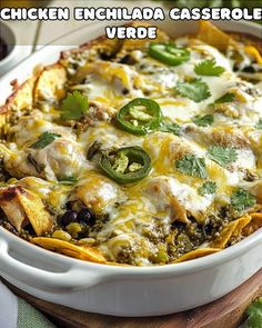 chicken enchilada casserole in a white dish with cheese and green peppers