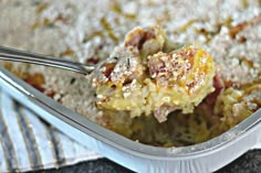 a close up of food in a pan on a table with a utensil