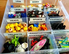 a plastic bin filled with lots of different types of legos and toys on top of a wooden table