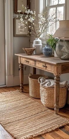 a wooden table with baskets on top of it next to a lamp and vases