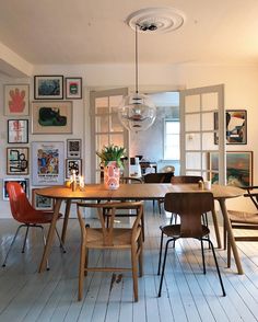 a dining room table with chairs and pictures on the wall