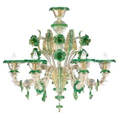 a green chandelier hanging from the ceiling with glass flowers and leaves on it