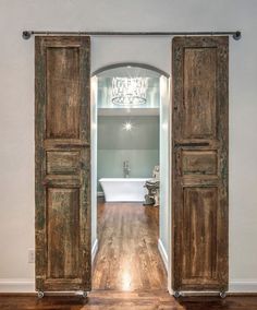 an open wooden door leading to a bathroom