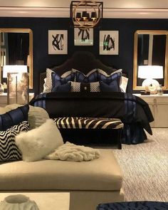 a bed room with a neatly made bed and two mirrors on the wall above it