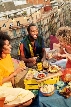 a group of people sitting around a table with food and drinks on top of it