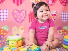 a baby sitting on the floor with toys