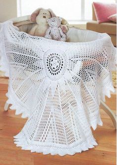 a white crocheted tablecloth with a teddy bear in the center on a wooden floor