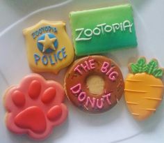 decorated cookies on a plate with the words zootopia and the big donut