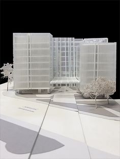 an architectural model of a building with trees in the foreground and other buildings behind it