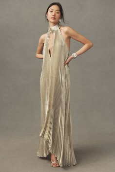 Embracing a flair for drama & grandeur, the Opera plays carefully with modern elegance. Featuring a high neckline, tie back halter and asymmetrical silhouette, this stunning billowing pleat full-length dress will transform you for an evening to remember. | Opera Halter Cutout Maxi Gown by L'IDÉE in Gold, Women's, Size: 8, Polyester/Tin at Anthropologie Nola Wedding Guest Dress, Elegant Clothing For Women, Cruise Black Tie Dress, Gold Black Tie Dress, Wedding Guest Summer Formal, New Years Gown, Opera Dress Gowns, Eclectic Cocktail Dress, Micro Pleated Dress