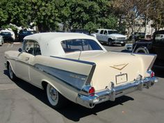 an old white car parked in a parking lot