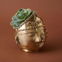 * Indian tribal woman face pot for succulents plants. * Measures 3" length, 3" width, and 4" height. * Made from brass, an alloy of zinc and copper alloy. * Crafted using the lost wax metal casting technique. * Crafted by Dhokra tribe, a community of metal smiths of India. ---------------------------------Dhokra Damar tribes are a community of metal smiths from the states of Orissa and West Bengal in India. These tribes are known for non-ferrous metal casting. They work with copper and its alloy Iron Plant Stand, Face Planters, Non Ferrous Metals, Iron Plant, Metal Planters, Ceramics Pottery Art, Planter Pots Indoor, Lost Wax, Metal Crafts