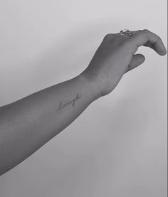 a person's arm with a small tattoo on the left side of their arm