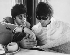 two young men sitting next to each other at a table