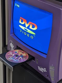 a purple television sitting on top of a metal stand next to a dvd disc holder