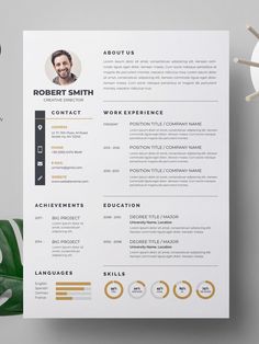 a clean and modern resume template is displayed on top of a white table with green leaves