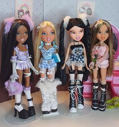 four dolls are standing next to each other