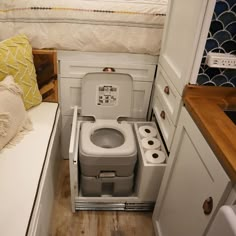 a small bathroom with a toilet in the corner and some rolls of toilet paper next to it