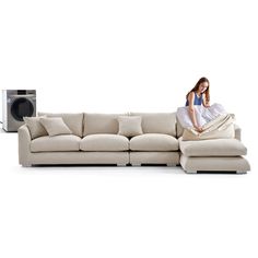 a woman sitting on top of a white couch next to an audio player and speakers