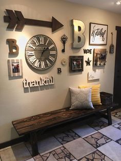 a bench sitting in front of a wall with many pictures and clocks on the wall