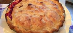 a pie sitting on top of a table next to a plate with fruit in it