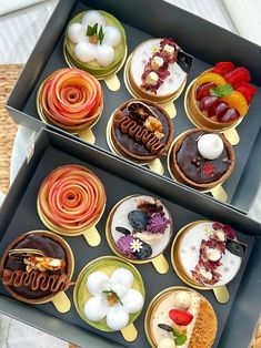 there are many different types of donuts in the box on the table and one is decorated with icing