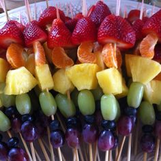 fruit skewers with strawberries, oranges, grapes and pineapple on sticks