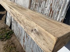 an old wooden bench sitting in front of a building with peeling paint on the siding