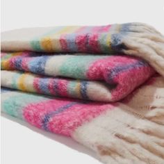 three multicolored woolen blankets folded on top of each other with the same pattern