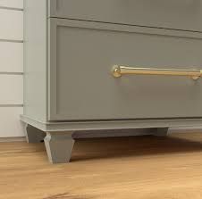 a grey dresser with gold handles on it