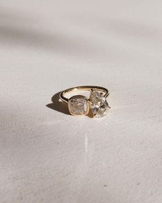 a gold ring with two diamonds on it