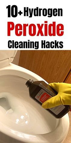 a person in yellow gloves is cleaning a toilet with a bottle of liquid on it