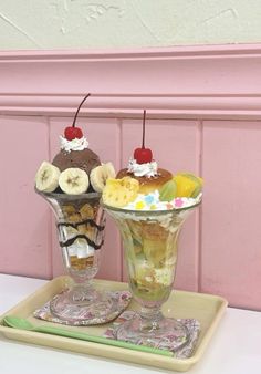 two desserts on a tray in front of a pink wall