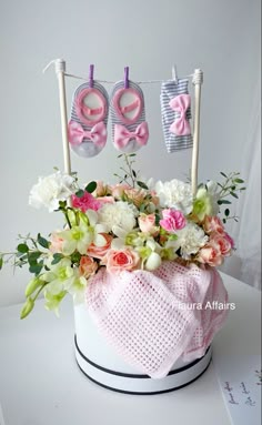 a pink hat with flowers and baby shoes on it